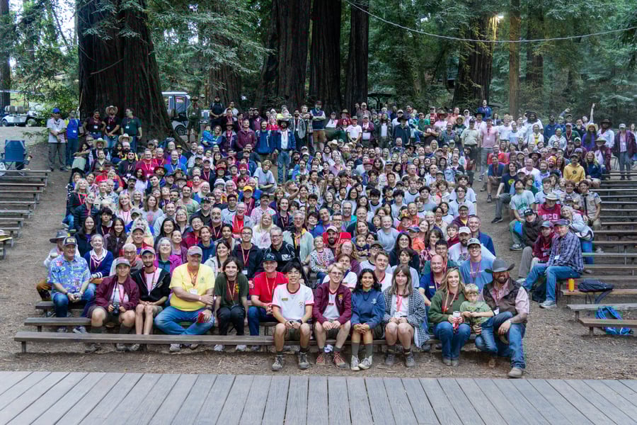 Royaneh 100 large group photo of everyone sitting on benches facing the camera and smiling